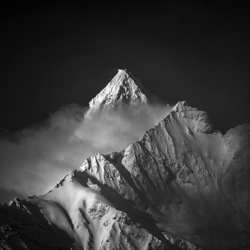 Sommet alpin enneigé émergeant des nuages – symbole de vision et d’exigence – Hot Zone Rescue